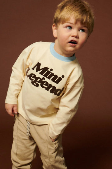 Longsleeve dziecięcy beżowy z nadrukiem "Mini Legend" - She Is Sunday