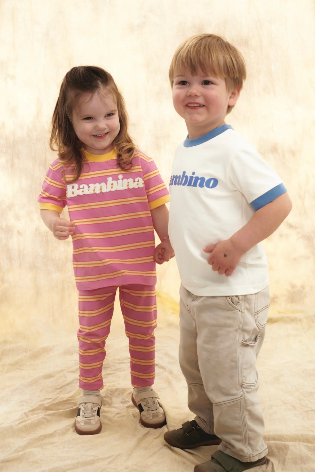 T-shirt dziecięcy różowy w kolorowe paski z napisem "Bambina" - She Is Sunday